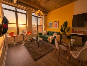 A modern living room with a sofa, chairs, a coffee table, and a TV. - McCormick Place 2b/2b family unit with optional parking for up to 8 guests (Chicago)
