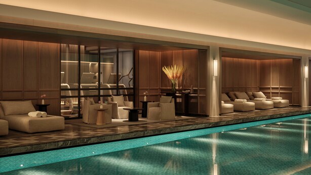 Zona de piscina interior moderna con asientos y vistas a la piscina.