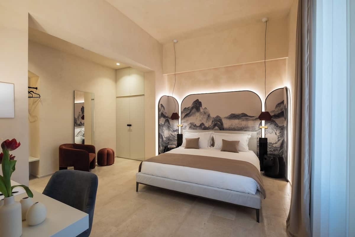 Une chambre moderne avec un grand lit, un bureau avec une chaise et un coin repas.