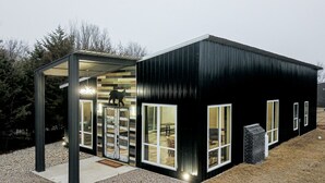 A modern black building with large windows and a covered entrance.