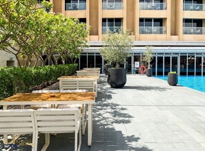 Relax by the pool with comfortable seating and lush greenery.