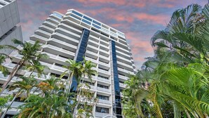 A high-rise hotel with multiple balconies, surrounded by palm trees. - The Lookout at Northshore Tower- Waterfront Luxury with Panoramic Sea Views (Cairns North)