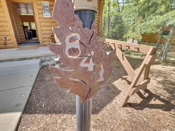 Una escultura de metal con el número 841, un banco de madera y un edificio al fondo.