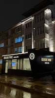 Un edificio con un letrero que dice 'HOME SUIT APART & OTEI' y un logotipo con una 'H' mayúscula.