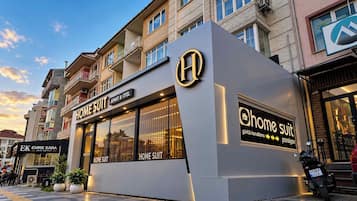 A building with a prominent 'HOME SUIT' sign, indicating a hotel or accommodation service.
