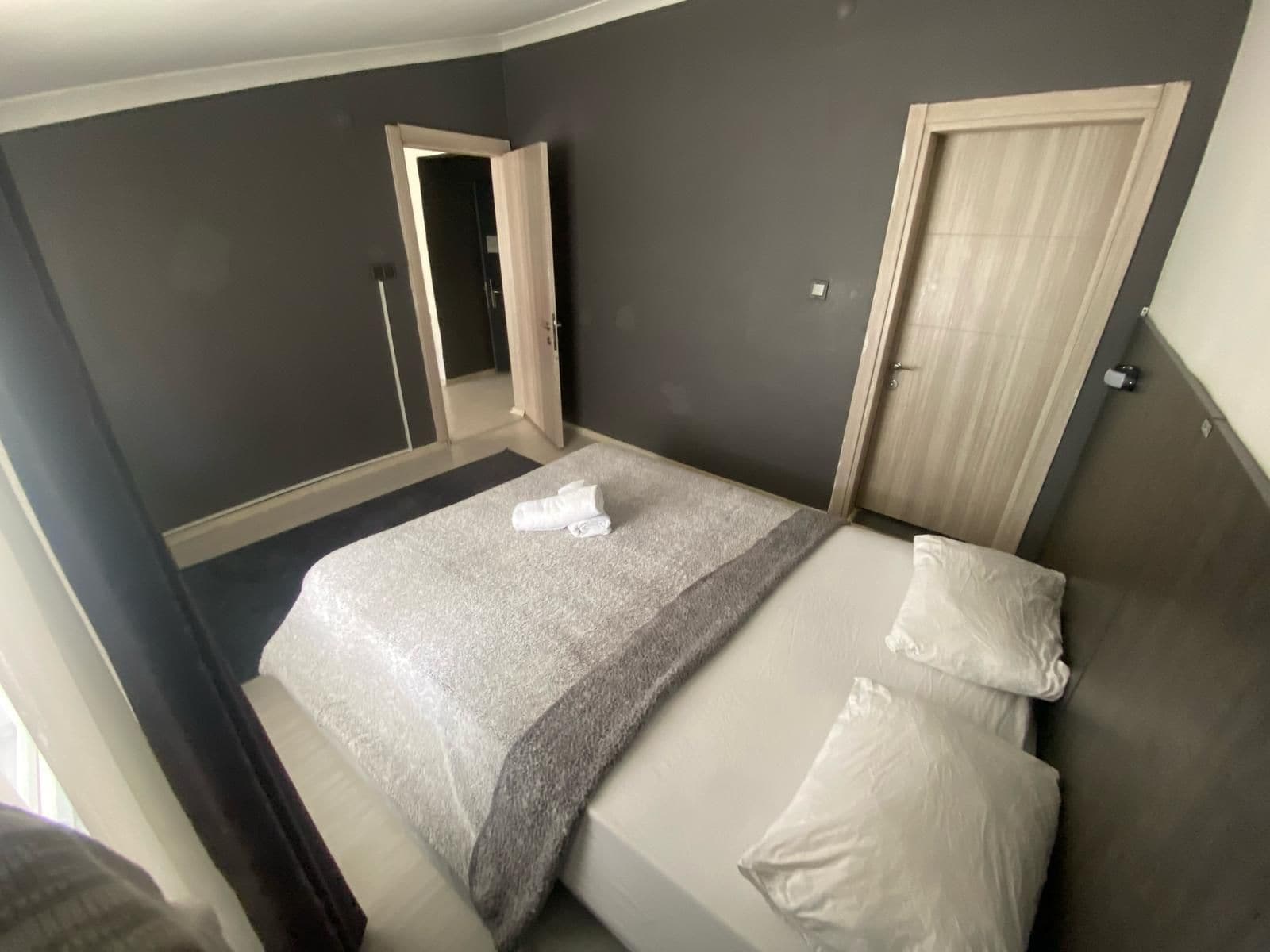 Une chambre à coucher avec un lit, une porte et un miroir.