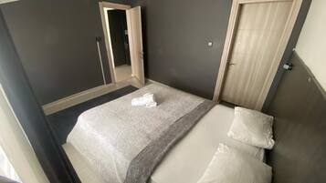 Une chambre à coucher avec un lit, une porte et un miroir.
