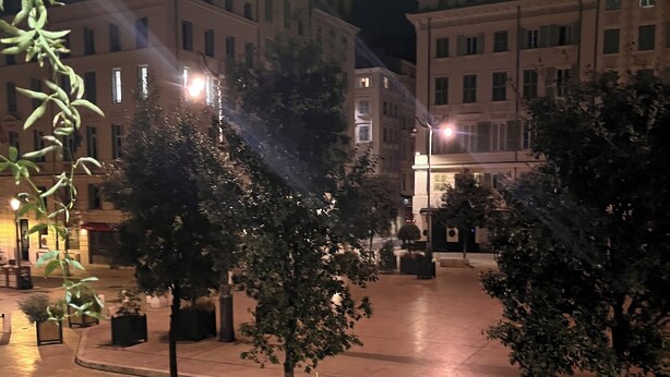 A nighttime urban square with trees and buildings. - Hotel Relax (Marseille)