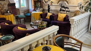 A room with a yellow table, purple sofas, and a white railing. - Hotel Relax (Marseille)