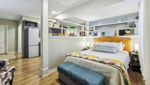 A bedroom with a bed, bedside tables, a wardrobe, a built-in shelf unit, and a refrigerator. - Chic 1-bedroom with WiFi and AC in fabulous Alpharetta - Blue Gate (Alpharetta)