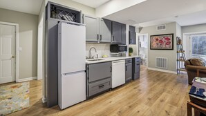 A modern kitchen with grey cabinets, a white refrigerator, and a microwave. - Chic 1-bedroom with WiFi and AC in fabulous Alpharetta - Blue Gate (Alpharetta)