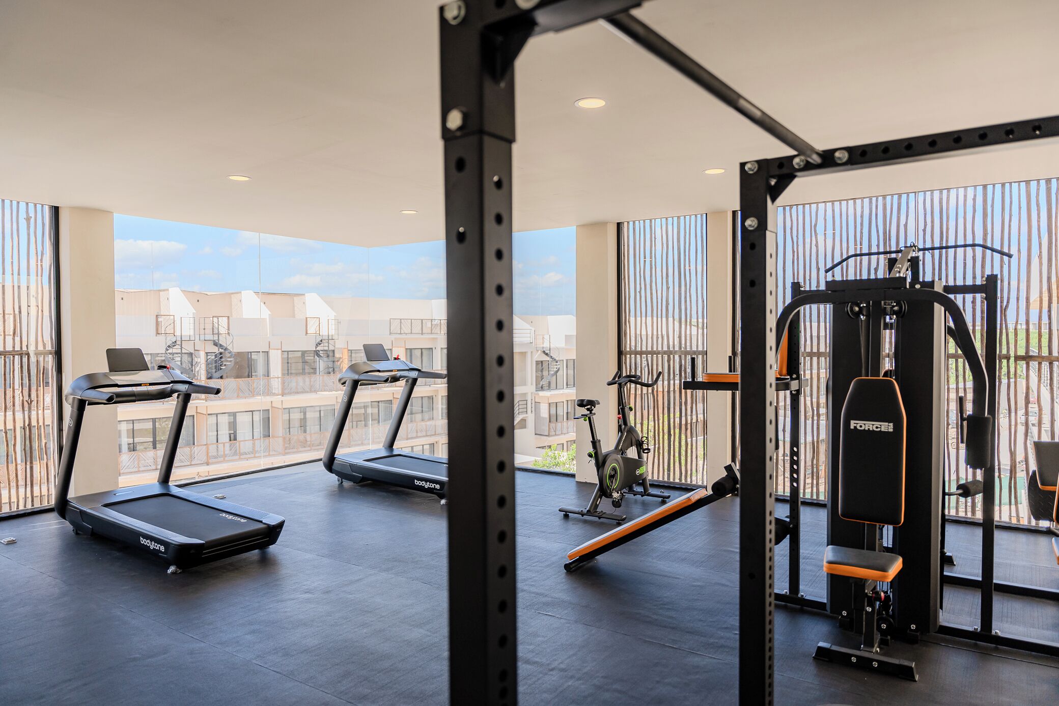 A gym with treadmills, an exercise bike, and a weightlifting station.