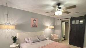 A bedroom with a bed, a chair, a ceiling fan, and a door. - Charming 2BE/2BA condo on Preston in Dallas (Dallas)