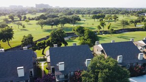 Stunning homes with sloped roofs and lush surroundings, set amidst a beautifully manicured golf course.