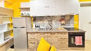 A modern kitchen with white cabinets, a stainless steel refrigerator, and a patterned backsplash. - BSB Apartment  (Tirana)