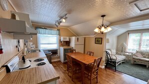Une cuisine de taille réduite, avec une table et des chaises en bois, un four à micro-ondes et un réfrigérateur.