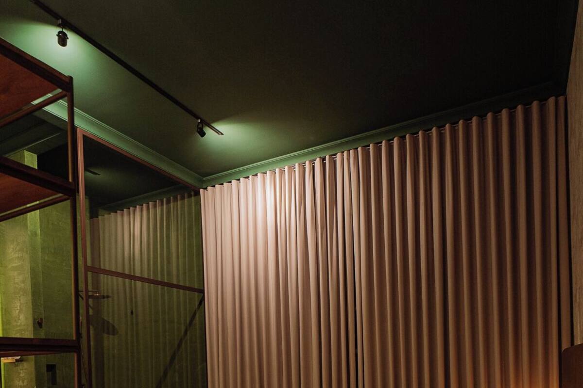 A bedroom with a bed, a bedside table, a chair, and a lamp.