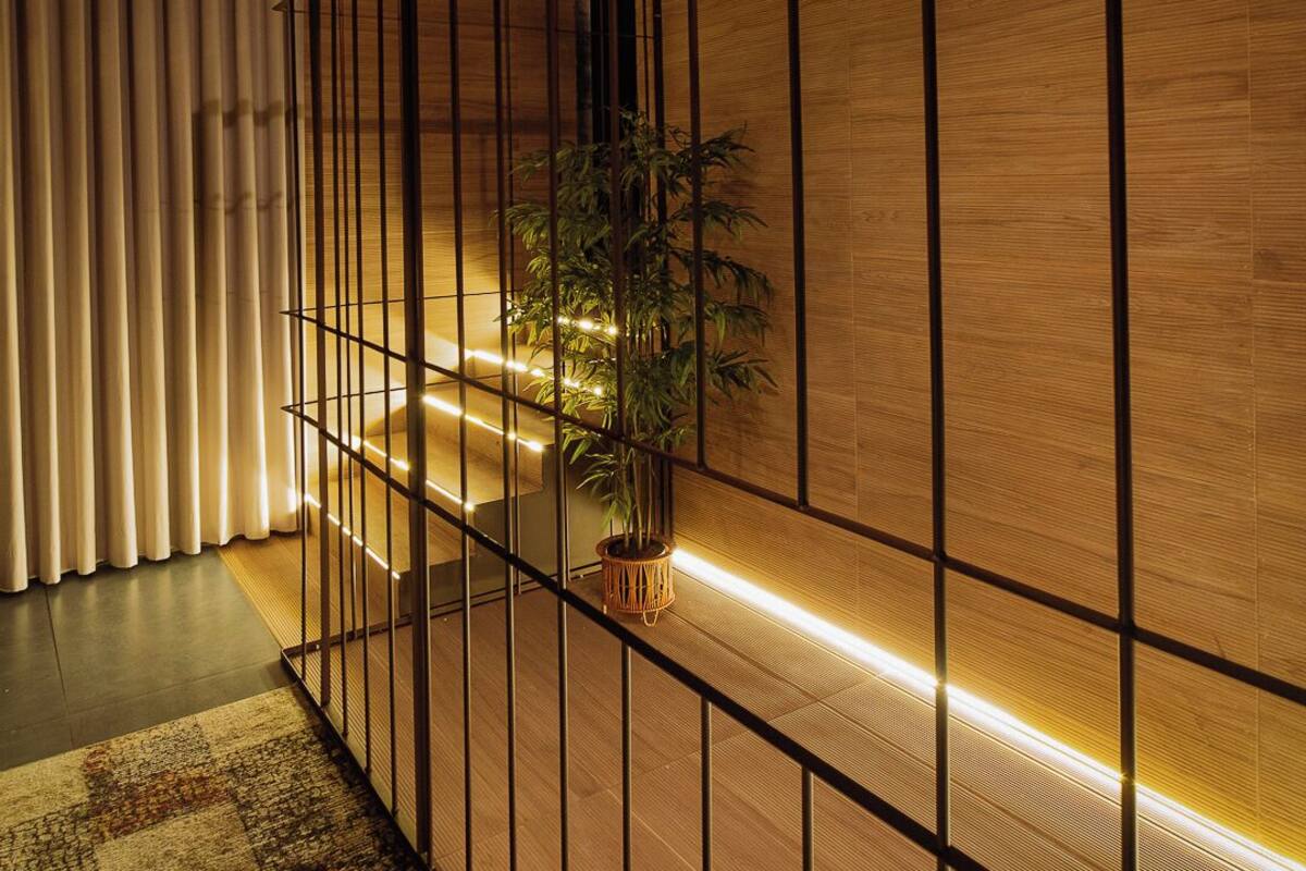 A modern interior with a wooden partition, recessed lighting, and a potted plant.