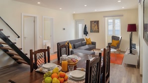 Una sala de estar moderna con comedor, una escalera y vistas al exterior.