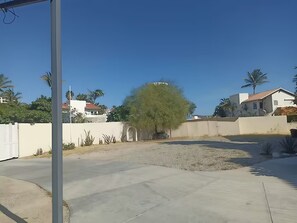 A residential area with a paved courtyard, a white fence, and houses with red roofs. - Hostal Hab. 2, En Zona Hotelera, Campo de Golf, con Alberca y Cerca de la Playa. (San José del Cabo)