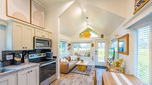 A spacious kitchen with modern appliances, a dining area with a wooden table, and a cozy seating area with a sofa and chairs.