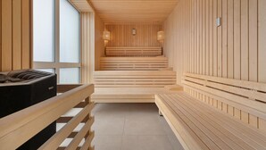A sauna with wooden benches and a bench with a sauna heater. - Fewo 3-13,Ostsee-Nordmole (Olpenitz)