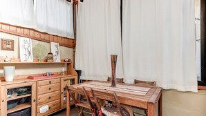A wooden dining table with chairs, a cabinet with drawers, and a window with curtains. - Garden House - Sweet Dreams in Florence (Firenze)