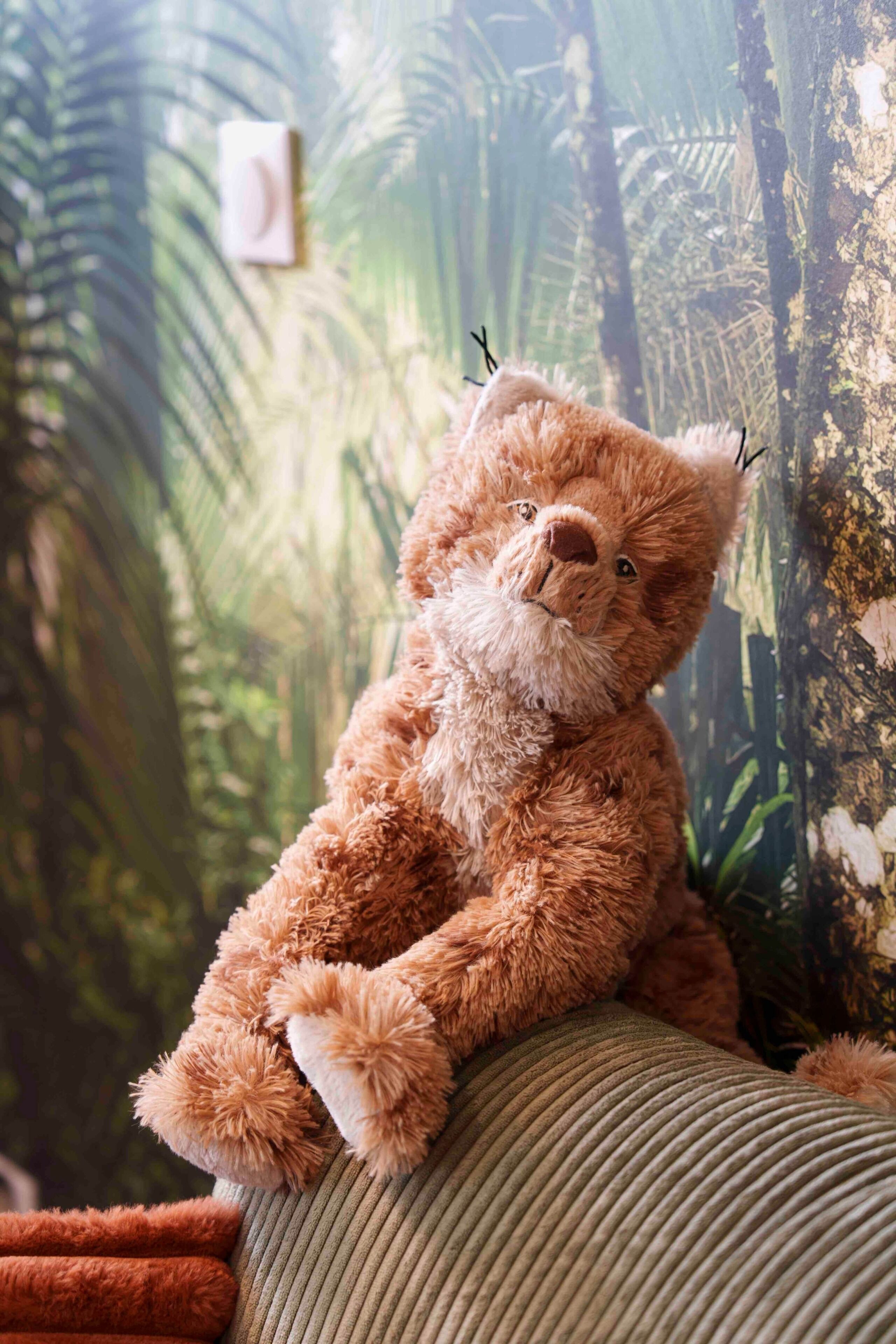 A plush teddy bear sitting on a textured, ribbed surface.