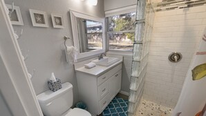 Une salle de bain avec des toilettes, un lavabo et une douche.