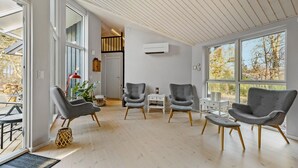 A modern living room with grey upholstered chairs, a white coffee table, and a wooden floor. - 5 bedroom nice home in Fårevejle (Fårevejle)