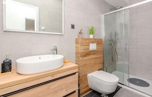 A modern bathroom with a freestanding bathtub, a toilet, and a glass-enclosed shower. - Cozy apartment in Privlaka with WiFi (Privlaka)