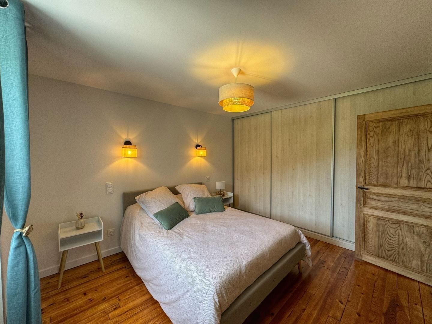 Une chambre à coucher avec un lit, des tables de chevet et une armoire.