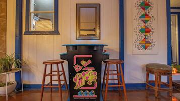 A bar area with stools, a mirror, and a wall with a colorful chart.