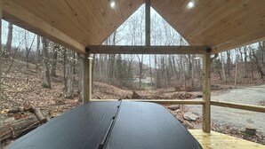 Ein überdachter Sitzbereich mit Blick auf einen Wald und eine Straße.