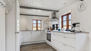 A kitchen with white cabinetry, a large window, and a built-in oven. - Nice home in Farsø with WiFi (Farsø)