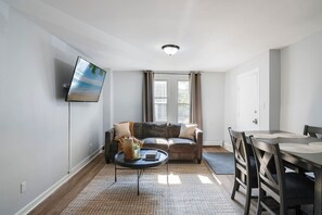 A modern living room with a sofa, a coffee table, and a dining table. - 3 Bedroom Beauty in Bloomfield (Bloomfield)