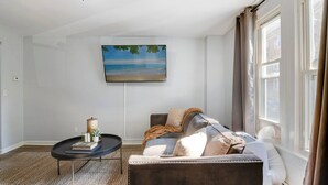 A living room with a sofa, a coffee table, and a painting on the wall. - 3 Bedroom Beauty in Bloomfield (Bloomfield)