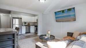 A modern living room with a sofa, a coffee table, and a TV mounted on the wall. - 3 Bedroom Beauty in Bloomfield (Bloomfield)
