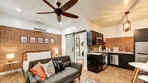 A modern apartment with a living room, kitchen, and a balcony. - Cocktails & Cacti | Encanto-Palmcroft Villa | Temp-Controlled Pool + Hot Tub | 4 Suites (Phoenix)