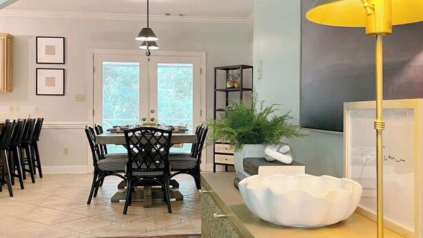 A dining area with a table and chairs, a pendant light, a potted plant, and a decorative bowl. - Savannah Home with Modern Airstream, Near Tybee (Savannah)