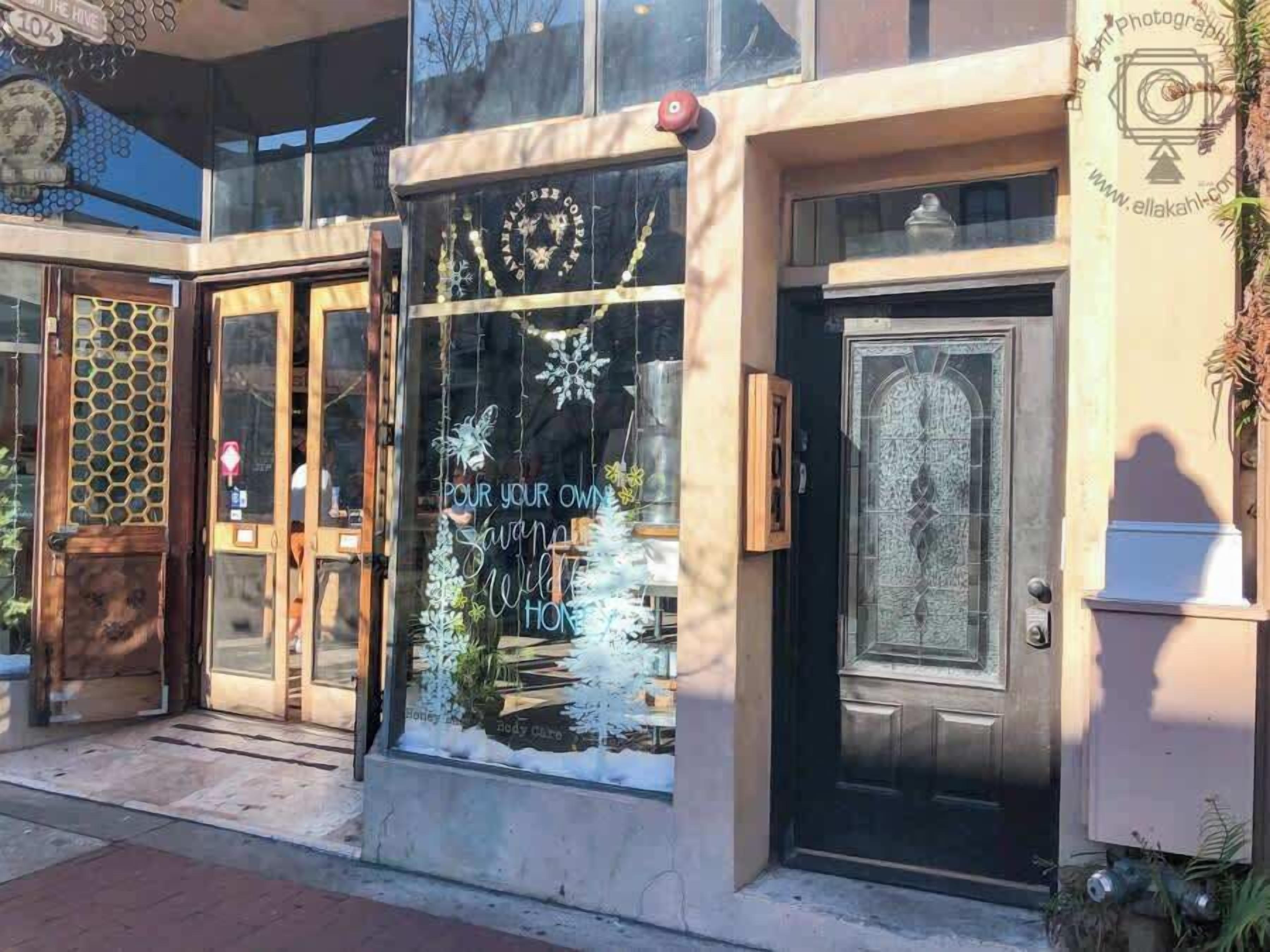 A building with a glass storefront displaying a sign that reads "Pour your own Sangria, Wild Honey, and Nody Care."