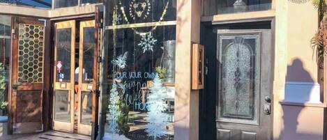 A building with a glass storefront displaying a sign that reads "Pour your own Sangria, Wild Honey, and Nody Care."