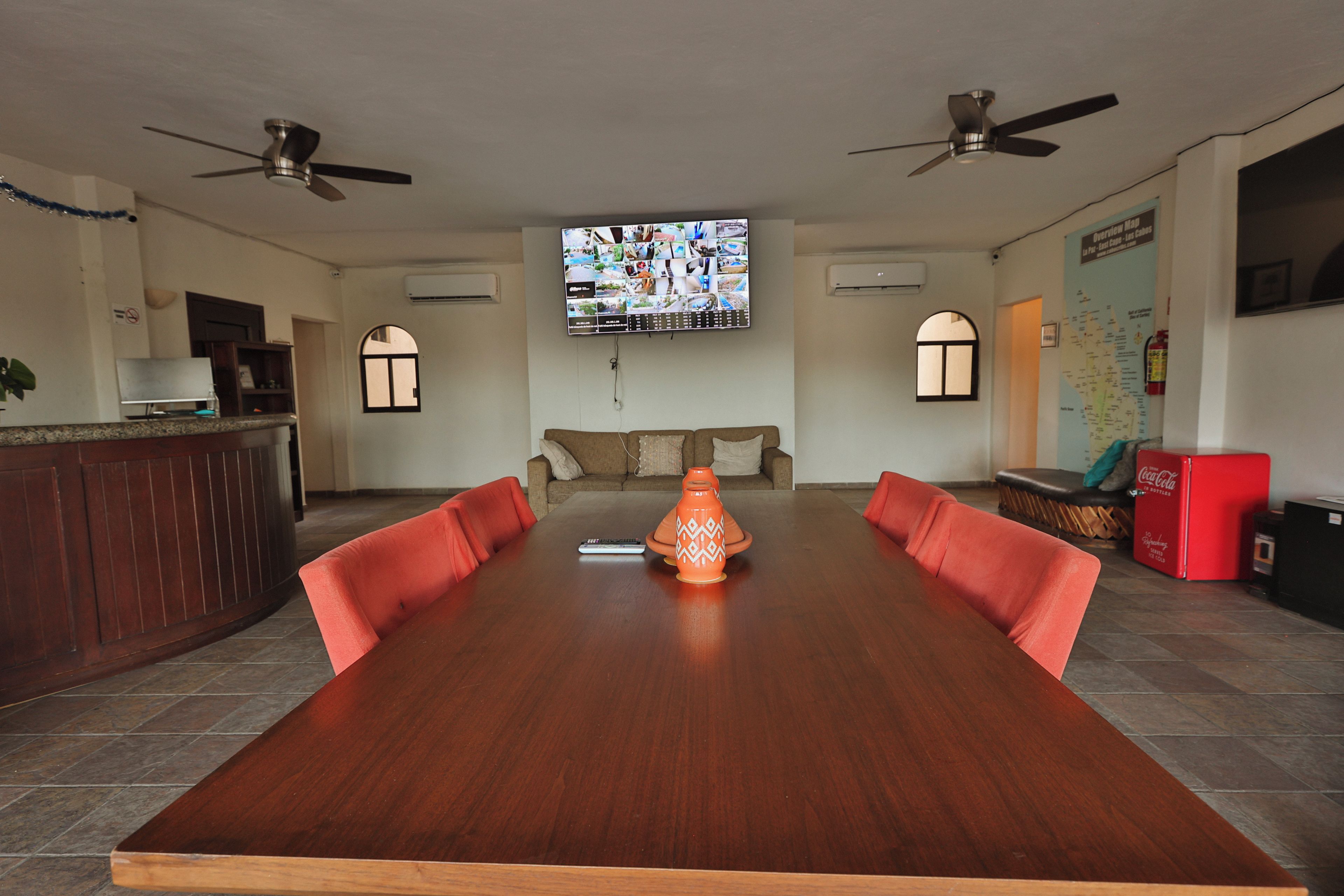 A conference room with a long table, two ceiling fans, a large screen, and a map on the wall.