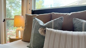 A bed with multiple pillows and a bedside lamp. - Poolside Family Haven Near Beach w/ Game Room (Savannah)