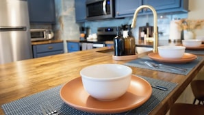 A modern kitchen with blue cabinets, stainless steel appliances, and a wooden countertop. - Dog-Friendly Savannah Cottage Near Tybee (Savannah)