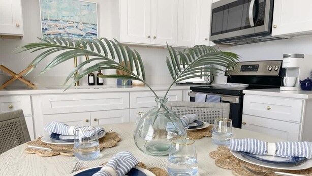 A dining table set with plates, glasses, and a vase. - Modern Duplex 3 Blocks from Forsyth Park (Savannah)