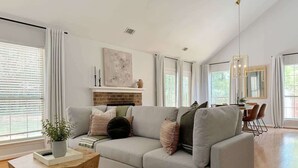 Una sala de estar moderna con un sofá gris, una mesa de centro de madera y una chimenea.