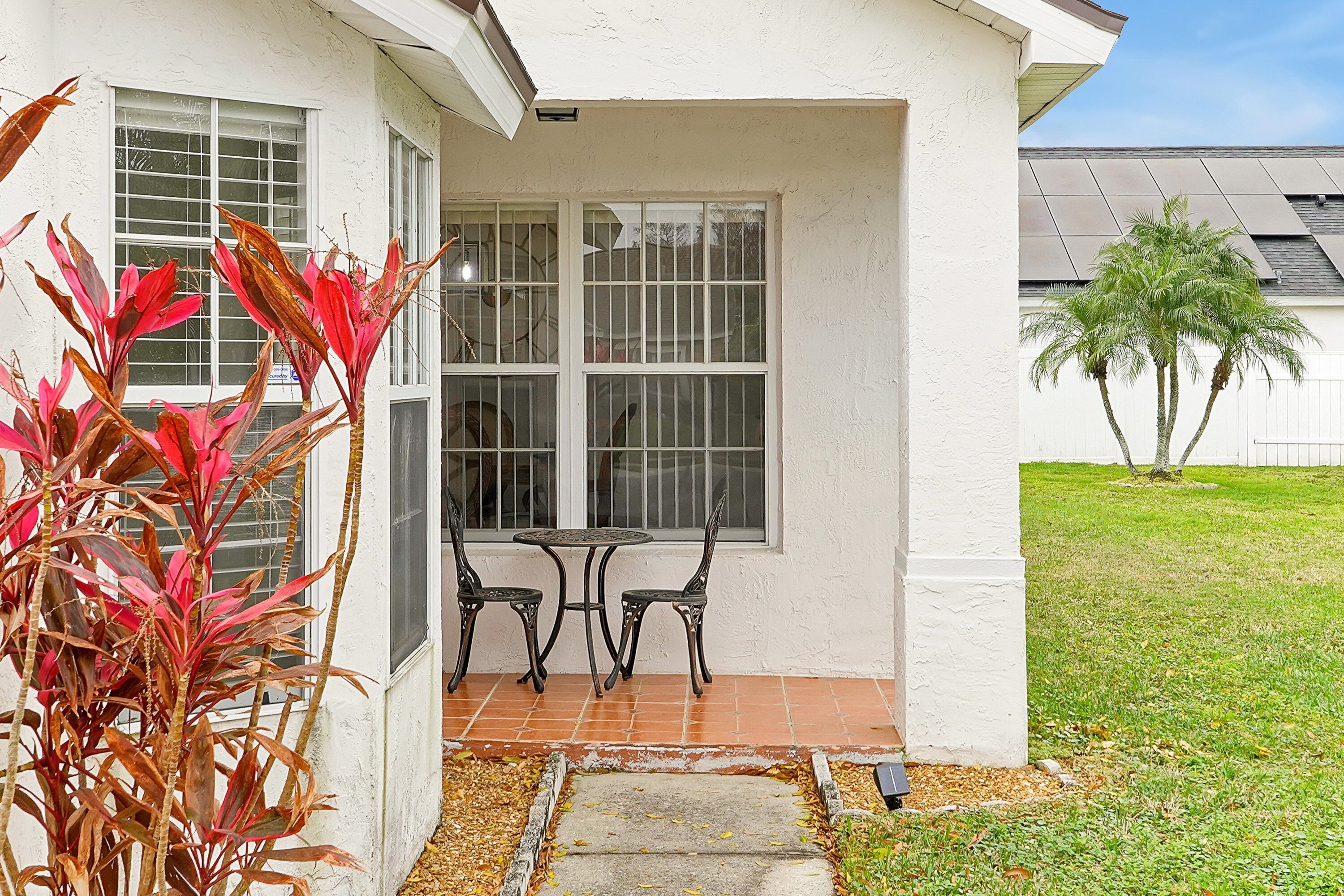 Une maison avec un patio, une table et des chaises.