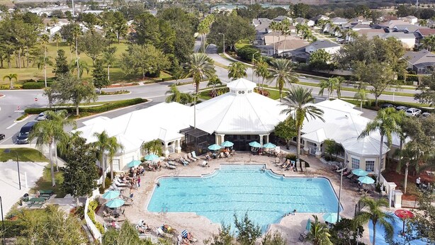 Ein Resort mit großem Pool, Liegestühlen und Palmen.