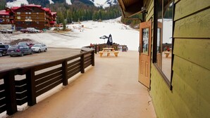 A wooden building with a balcony overlooking a snowy mountain area. - Ski In/Out Right to the Elk Chairlift (Fernie)